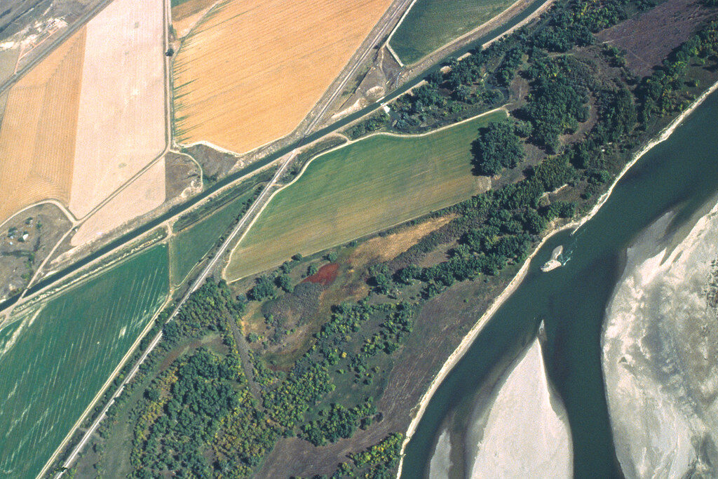 Vista aérea de curso d’água com mata ciliar entre áreas de cultivo