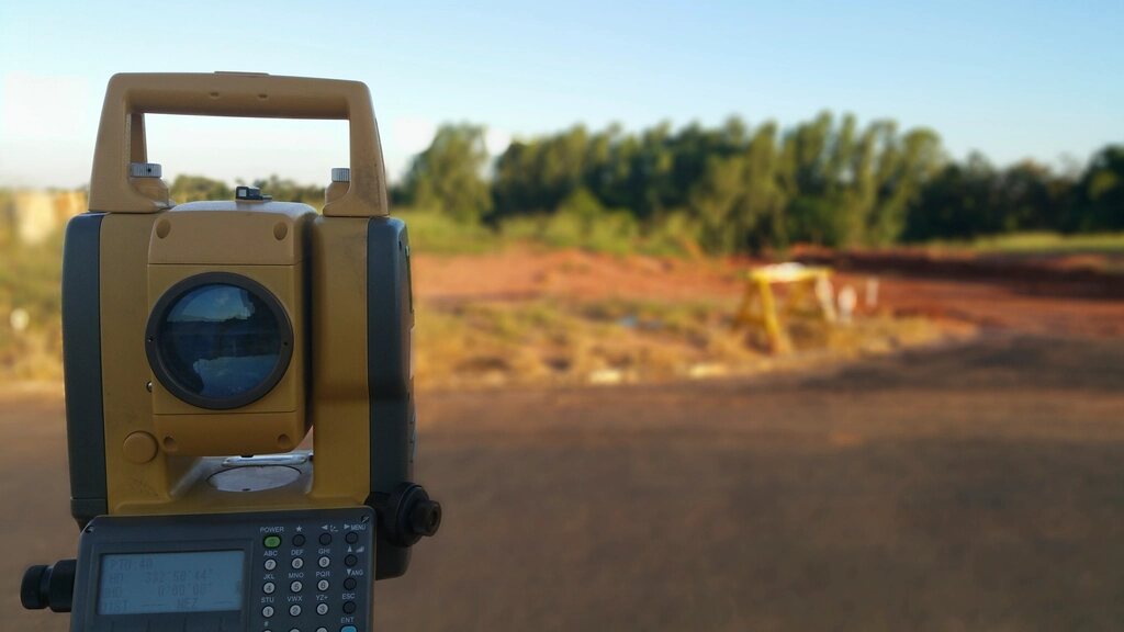 Estação total posicionada em área de levantamento topográfico